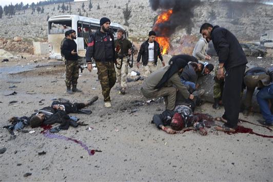 مسلحون ينقلون قتلى وجرحى التفجيرين الانتحاريين على معبر باب الهوى الحدودي بين سوريا وتركيا امس (رويترز)