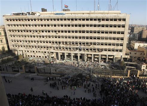 مواطنون وعناصر من الشرطة امام مبنى مديرية أمن القاهرة في منطقة باب الخلق بعد الانفجار امس (رويترز)