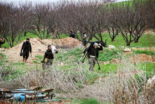 مسلحون يستعدون لمهاجمة قرية النزارية في شمال حماه امس الاول (ا ف ب)