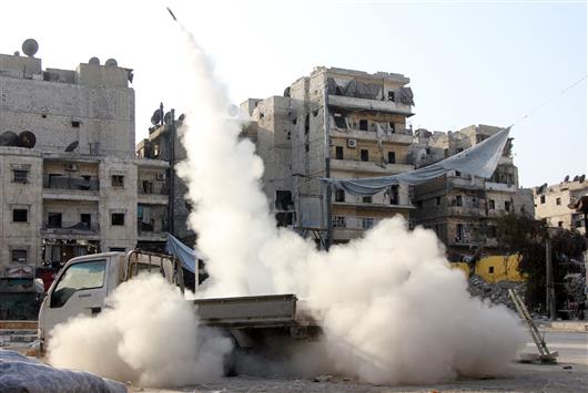 مسلحون يطلقون صاروخا في حلب أمس (ا ف ب)