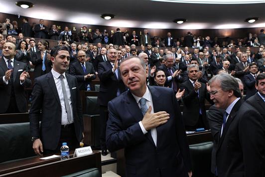 اردوغان يحيي نواب حزبه خلال اجتماعهم في مبنى البرلمان التركي في أنقرة أمس (أ ف ب)