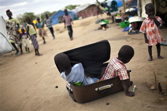 ولدان يجلسان في حقيبة أثناء اللعب في إحدى قواعد الأمم المتحدة في مدينة بور في جنوب السودان أمس	(أ ف ب)
