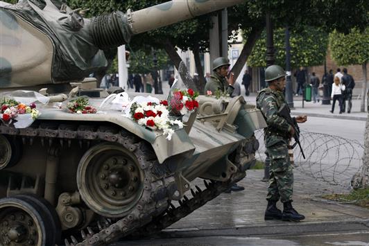 صورة تعود إلى 18 كانون الثاني 2011، بعد أربعة أيام على خلع بن علي، تظهر دبابة نثرت عليها الورود وعناصر من الجيش في وسط تونس العاصمة (أ ب)