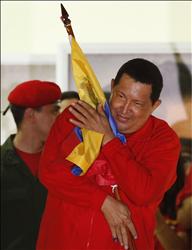 تشافيز يعانق العلم الفنزويلي خلال الاحتفال بفوزه على شرفة القصر الجمهوري وأمام مناصريه في كراكاس أمس . (رويترز) 