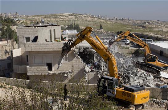 جرافات إسرائيلية تدمر منزلاً فلسطينياً في حي التور في شرق القدس المحتلة أمس (أ ف ب)