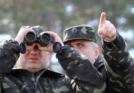 الرئيس الأوكراني المؤقت يتابع تدريبات للجيس على الرماية (أ ف ب)