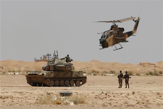 طوافة وآلية عسكرية أردنيتان تجوبان قرب معبر الكرامة (طريبيل) في الأراضي الأردنية أمس (رويترز)
