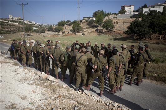 جنود الاحتلال يتلقون تعليمات قبيل إجراء اقتحامات بحثا عن المختطفين الثلاثة في قرية قرب مدينة الخليل أمس (أ ب)