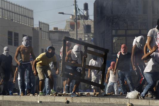 فلسطينيون خلال مواجهة مع قوات الاحتلال في شعفاط في القدس الشرقية امس (رويترز)