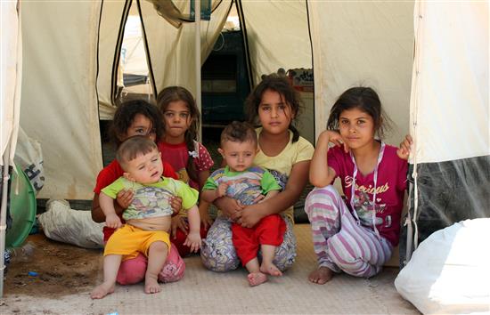 أطفال عراقيون يجلسون في مخيم للاجئين في قضاء خانقين قرب الحدود الإيرانية أمس (أ ب أ)