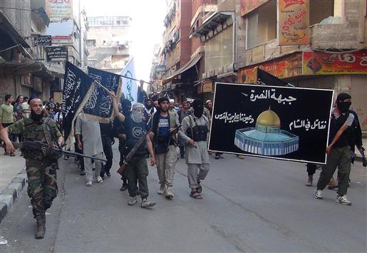 مسلحون من "جبهة النصرة" يحملون لافتة في مخيم اليرموك قرب دمشق في 28 تموز الحالي كتب عليها "نقاتل في الشام وعيوننا على بيت المقدس" (ا ف ب)
