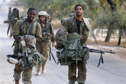 جنود إسرائيليون خلال انسحابهم من غزة أمس (رويترز)