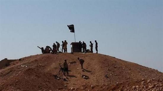 عناصر من «داعش» يرفعون رايتهم على أحد تلال مطار الطبقة
