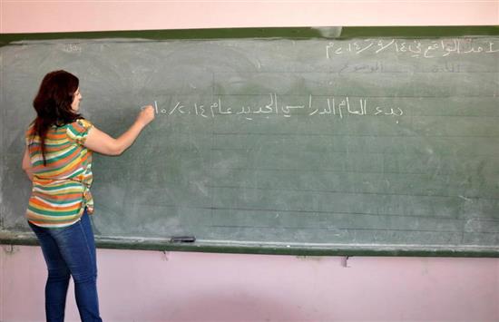 معلمة تكتب على اللوح عن بدء العام الدراسي في مدرسة في دمشق ("سانا")
