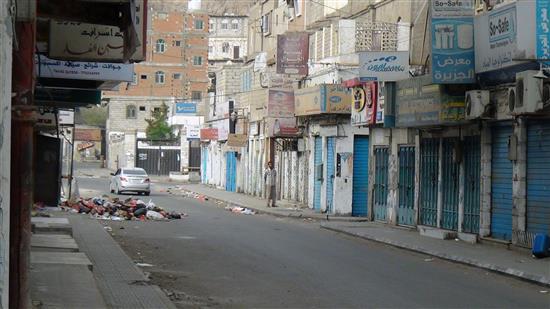 يمني يمشي في أحد شوارع عدن فيما يبدو أن كل المحال في المدينة أغلقت أبوابها (أ ف ب)