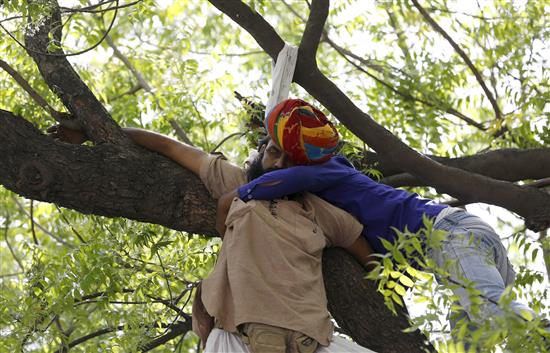  أحد الناشطين يحاول انقاذ الرجل من شنق نفسه في نيودلهي اليوم (رويترز)