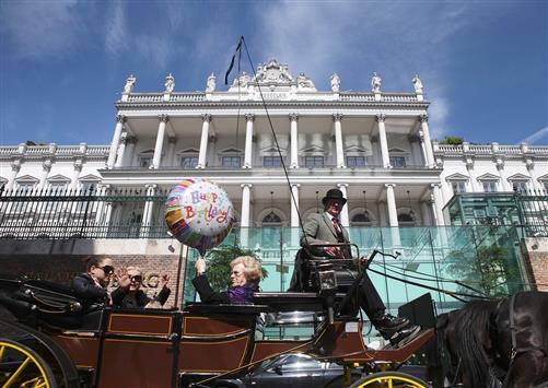 ركاب في عربة خيل يلوحون للمصورين أمام فندق قصر كوبورغ في فيينا حيث تعقد جولة مفاوضات نووية جديدة (رويترز)