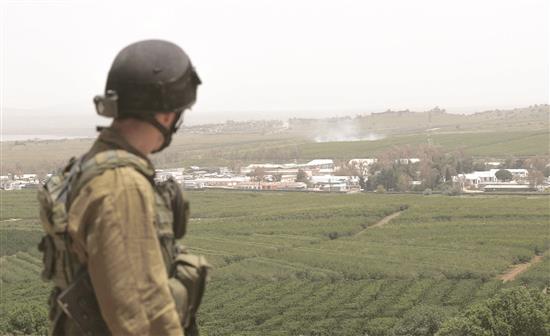 جندي إسرائيلي يراقب الاشتباكات بين «الجهاديين» قرب القنيطرة أمس (ا ب ا)