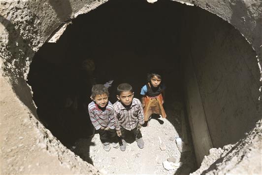 أطفال يمنيون يختبئون مع عائلاتهم في نفق للمياه في صنعاء، أمس (أ ب أ)