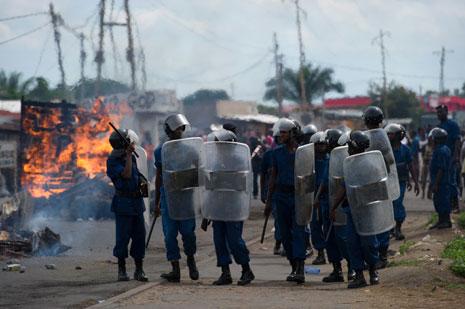 أفراد من الشرطة يمرون بحواجز نصبها متظاهرون في العاصمة بوجومبورا (أ ف ب)