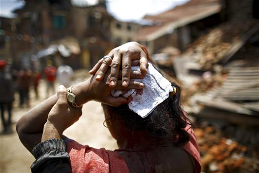 امرأة مصابة جراء الزلزال الذي ضرب منطقة سانخو، شرق العاصمة كاتماندو، أمس (رويترز)
