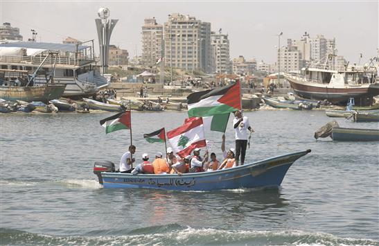 فلسطينيون يحملون علم بلادهم والعلم اللبناني في غزة امس في الذكرى الخامسة للهجوم الاسرائيلي على «اسطول الحرية» (رويترز)