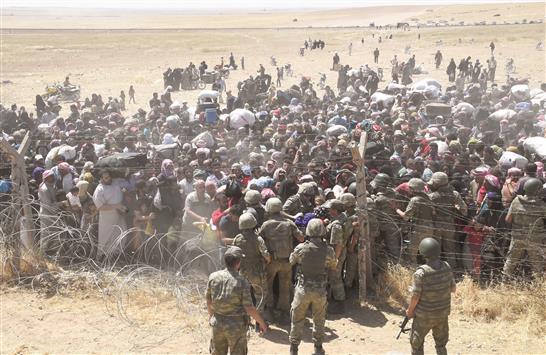 سوريون فروا من المعارك بين الاكراد و«داعش» على الحدود التركية امس (رويترز)