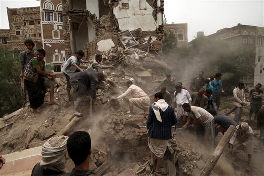 يمنيون يبحثون عن ناجين تحت الأنقاض جراء الغارة التي استهدفت صنعاء القديمة، امس (رويترز)