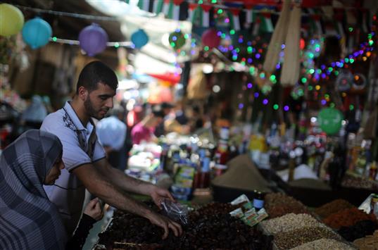 سيدة فلسطينية تشتري من سوق في مدينة غزة تحضيراً لبداية شهر رمضان، أمس (أ ف ب)