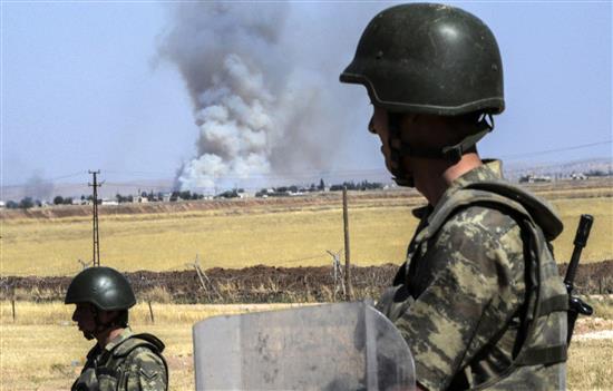 جنديان تركيان يراقبان الدخان يتصاعد من عين العرب السورية بعد اقتحامها من قبل "داعش" أمس (ا ف ب)