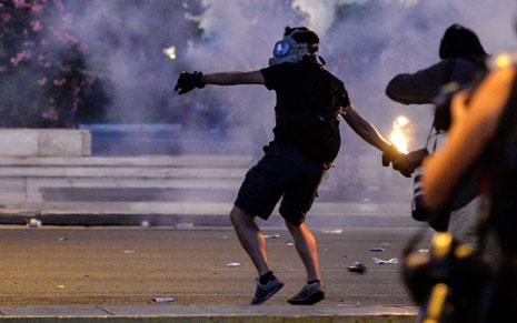 محتجون على الاتفاقية يلقون قنابل حارقة أمام البرلمان اليوناني أمس (أ ف ب)