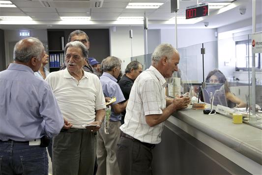 يونانييون يسحبون المال من مصرف بيرايوس في جزيرة كريت في اليونان (رويترز)