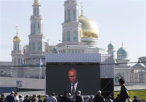 مواطنون يستمعون إلى كلمة بوتين اليوم لدى افتتاح المسجد الكبير في موسكو (أ ف ب)
