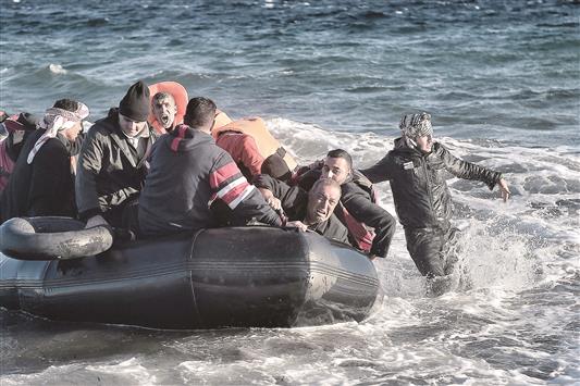 لاجئون يصلون إلى جزيرة لسبوس اليونانية بعد عبورهم على متن قارب مطاطي بحر إيجه من تركيا (أ ف ب)