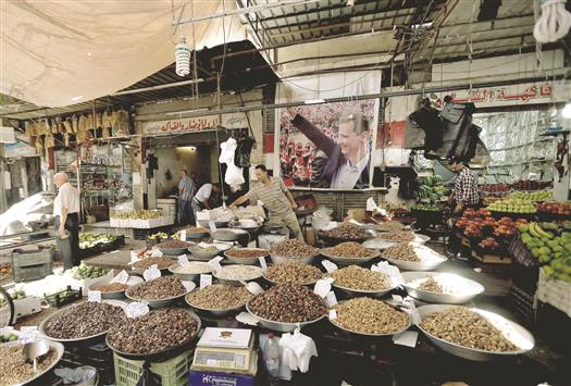 سوريون يتبضّعون من سوق في دمشق قبل العيد (أ ف ب)