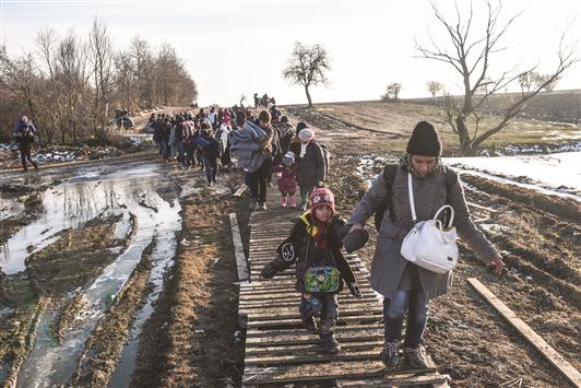 لاجئون يواصلون طريقهم سيراً على الأقدام بعد عبور الحدود من مقدونيا إلى صربيا أمس (أ ف ب)