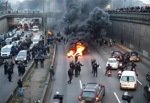 محتجون يحرقون دواليب السيارات في شوارع باريس (أ ف ب)