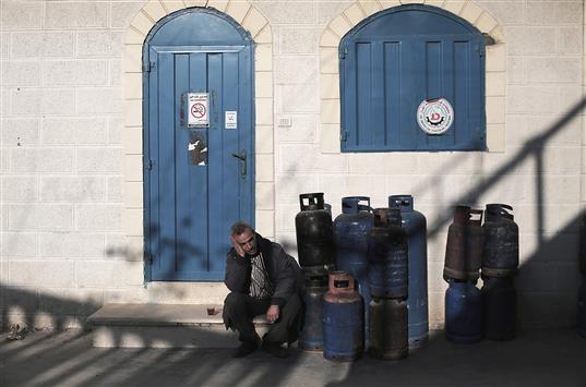 فلسطيني ينتظر دوره لتعبئة قارورة غاز في محطة للغاز في وسط غزة. وتقوم محطات الغاز في القطاع بتعبئة القوارير إلى نصفها فقط نظراً لنقص حاد في استيراد الغاز من الأراضي المحتلة (أ ب أ)