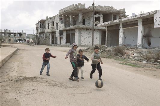 اطفال يلعبون كرة القدم في بصرى الشام في ريف درعا امس الاول (رويترز)