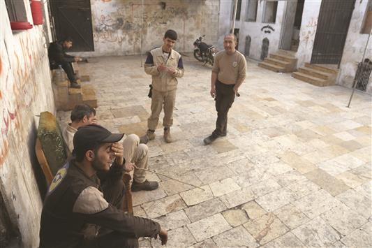عناصر في «الدفاع المدني» السوري يستريحون في مقرهم في حي باب النيرب في حلب امس (ا ف ب)