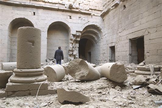 رجل يتفقد الدمار في قلعة بصرى الشام في ريف درعا جراء ما قال معارضون إنه غارة للطيران السوري أمس الأول (رويترز)