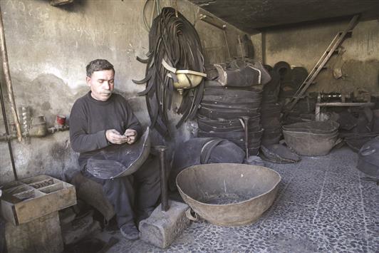 رجل يقوم بإعادة تدوير دواليب في معرة النعمان في ريف ادلب امس الاول (رويترز)