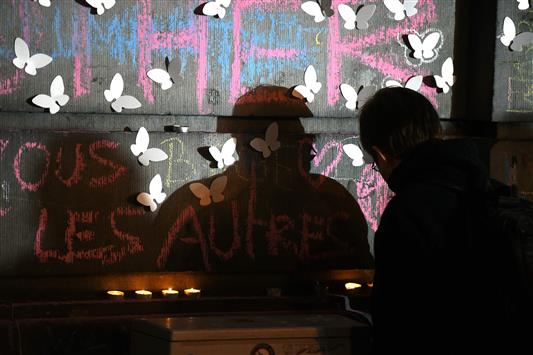 رجل يضيء الشموع تضامناً مع الضحايا الذين سقطوا في هجمات بروكسل في ساحة البورصة وسط العاصمة بروكسل (أ ف ب)