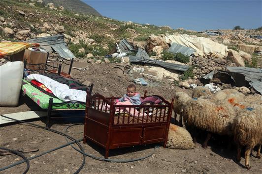 طفل فلسطيني داخل سريره بعد هدم الاحتلال الاسرائيلي منزل العائلة في خربة طانا قرب نابلس امس (ا ف ب)