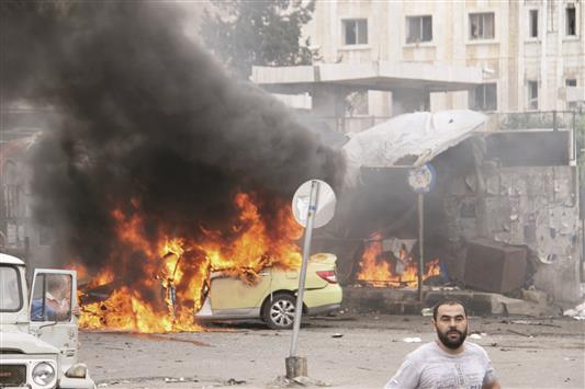 اندلاع النيران في الموقع الذي شهد تفجيرات إرهابية في مدينة طرطوس أمس (أ ف ب)