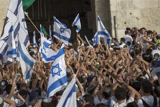 مستوطنون إسرائيليون يرفعون الأعلام الإسرائيلية أمام باب دمشق في القدس القديمة في الذكرى الـ49 للنكسة أمس (أ ب أ)