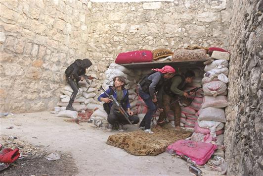 مسلحون في حي كرم الطراب في حلب امس (رويترز)