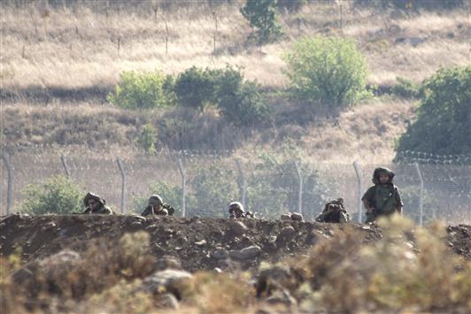 جنود اسرائيليون يتخذون مواقع في مرتفعات الجولان المحتلة كما يبدون من قرية بئر عجم السورية في محافظة القنيطرة أمس الأوّل (رويترز)
