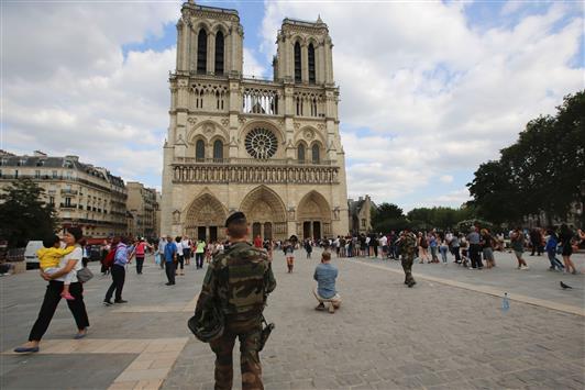 جندي فرنسي امام كاتدرائية نوتردام في باريس قبل قداس تأبيني للكاهن الذي ذبحه متطرف اسلامي في منطقة النورماندي امس (أ ف ب)