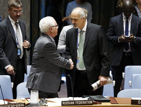 سفير روسيا لدى الأمم المتحدة، فيتالي تشوركين مصافحاً الجعفري خلال جلسة خاصة لمجلس الأمن الدولي بشأن الوضع في سوريا في نيويورك أمس (أ ب أ)